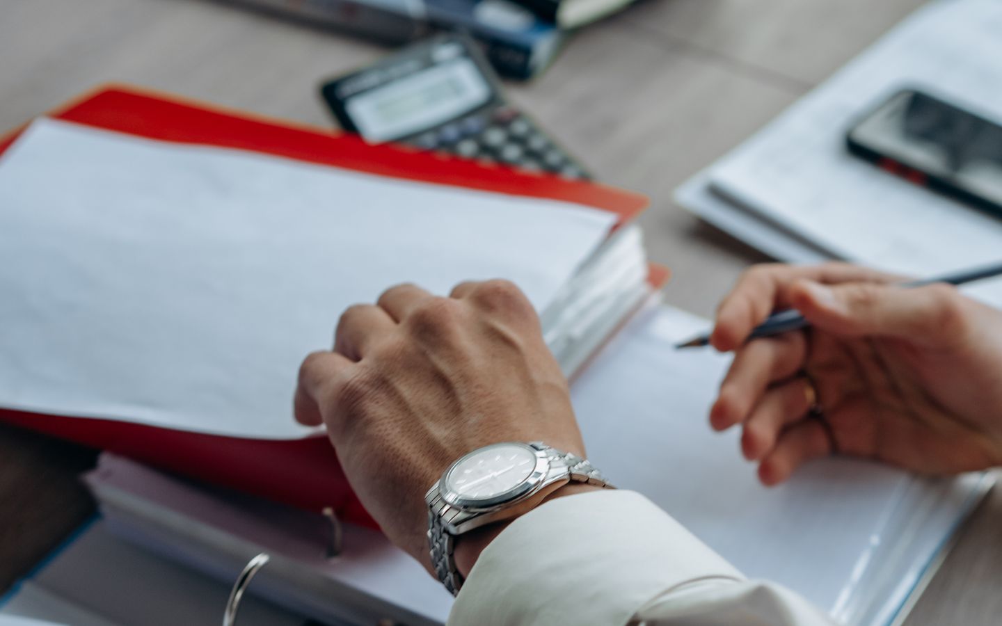 A person carefully reviewing official paperwork at a desk