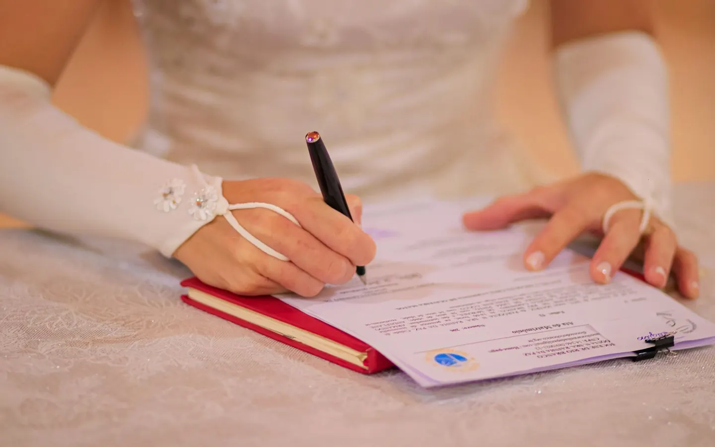 Bride signing a marriage certificate during a wedding ceremony