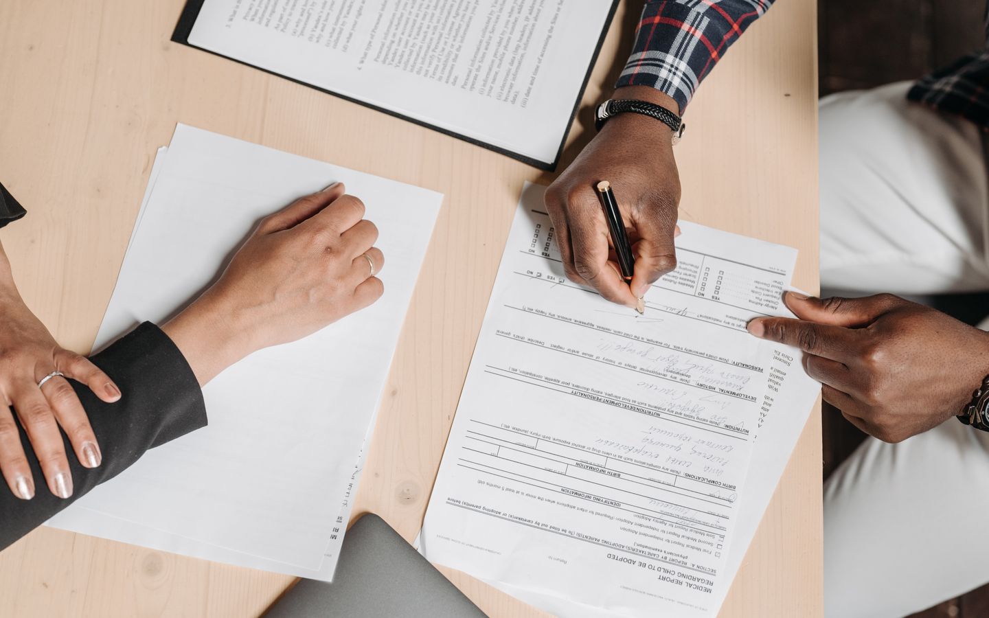 Two people reviewing and signing business paperwork